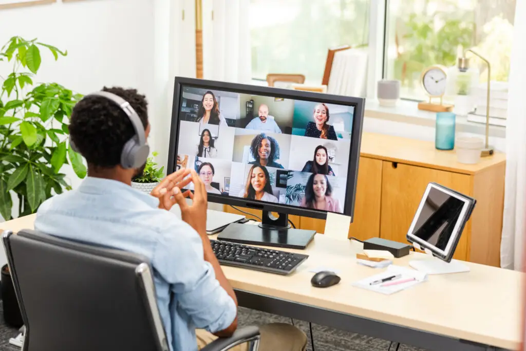 Diverse team participates in a virtual meeting using technology. Successful teamwork and communication.